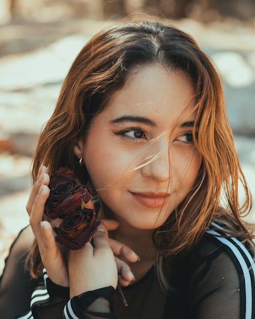 A woman with long hair and a flower in her hand