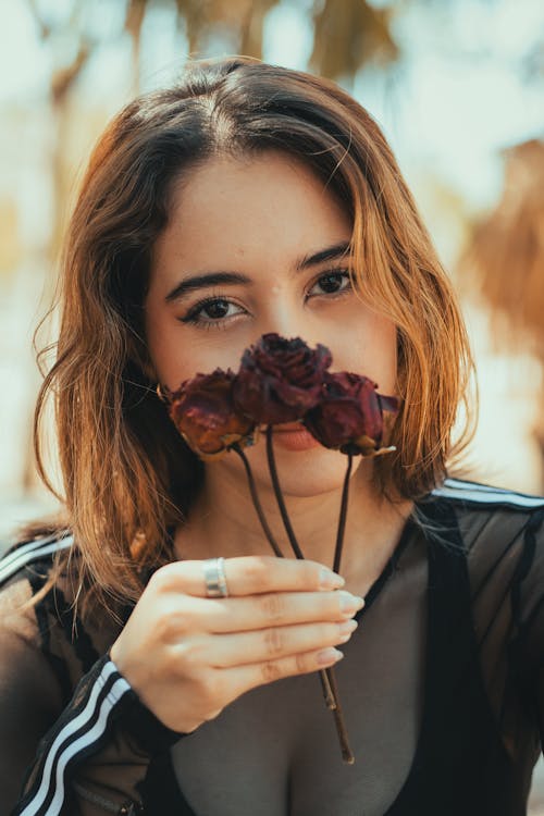 A woman holding a rose in her hand