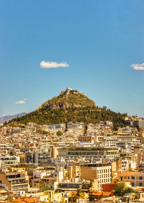 Free Panoramic cityscape of Athens with Mount Lycabettus under a clear blue sky. Stock Photo