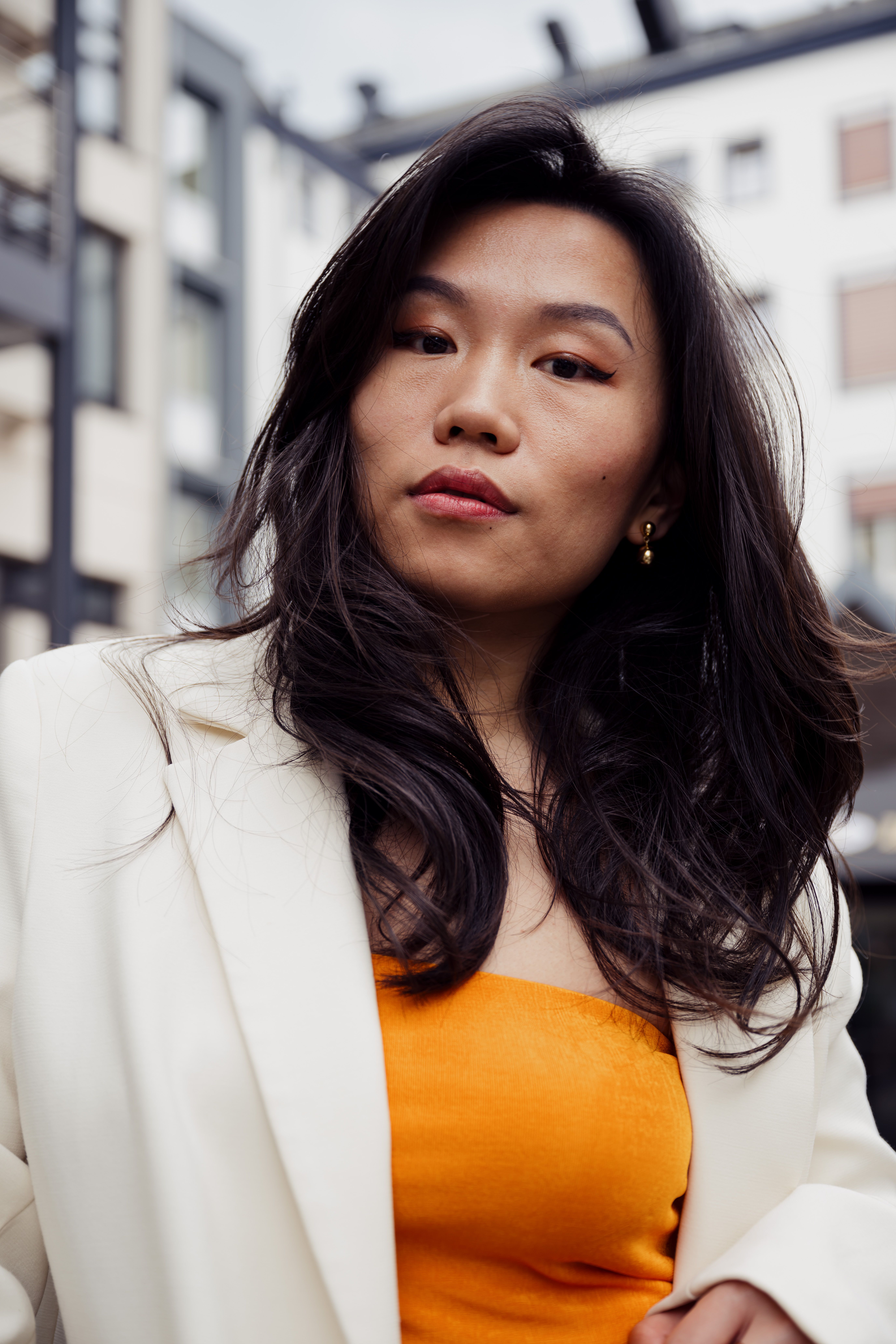 Close-up portrait of a young woman in a chic urban setting, capturing modern fashion and confidence.