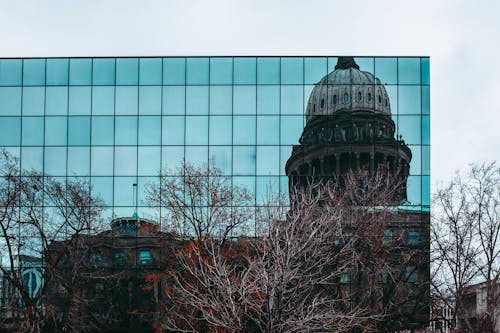 A building with a dome reflected in the glass