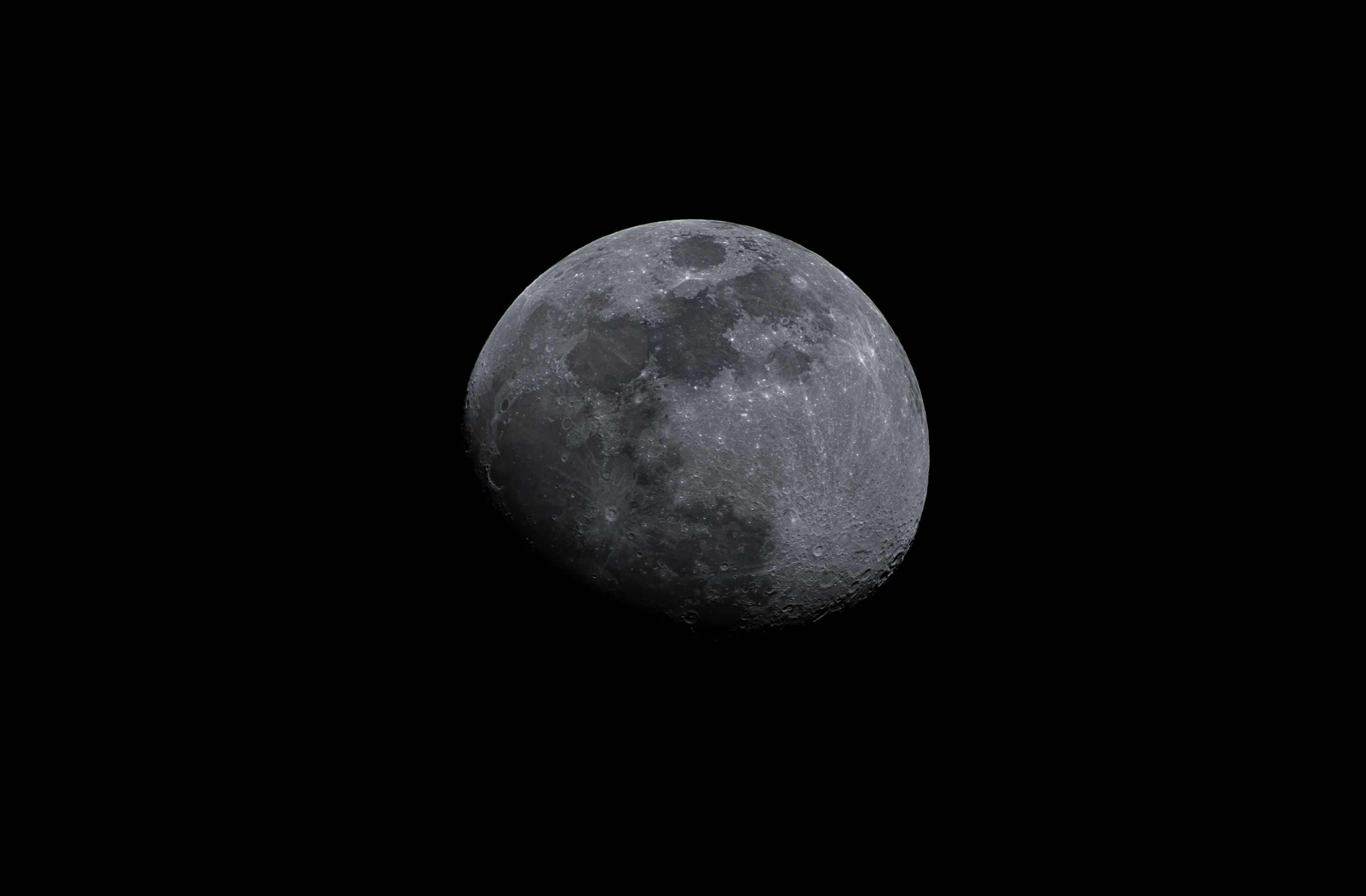 Capture of the moon showcasing craters and shadow with a dark sky backdrop.