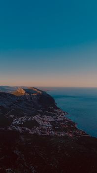 A breathtaking aerial view of the Sardinian coastline and sea at sunset, showcasing natural beauty.