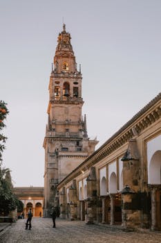 A stunning view of the iconic Mosque-Cathedral tower in Córdoba, Spain, showcasing its historic architecture at dusk.