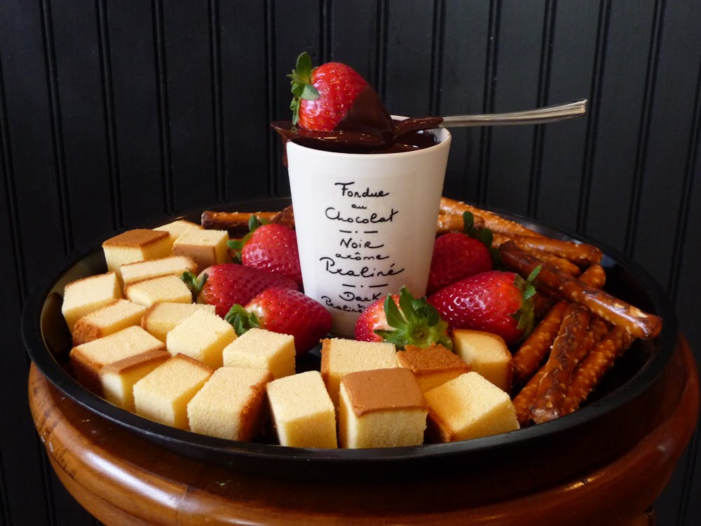 Free White Ceramic Mug on Top Sppon and Strawberry Surrounded Leche Plan and Strawberry on Black Round Shape Tray Stock Photo