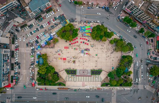 Bird's eye view of a city square in Jiujiang with surrounding traffic and greenery.