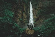 在郁郁葱葱的森林中欣赏高大的瀑布，能让人感受到冒险与探索的乐趣