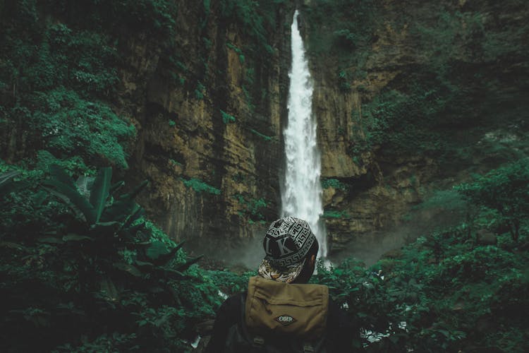 Man Standing Near Waterfall