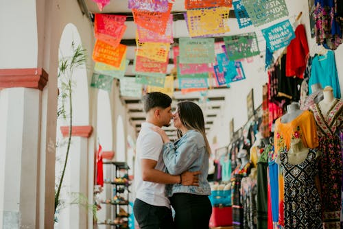 Couple hugging in front of colorful hanging banners