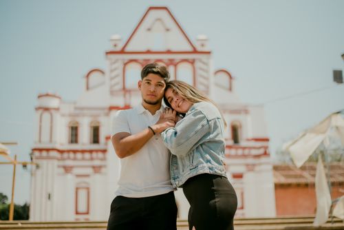 Free A young couple embracing romantically in front of a historical building, symbolizing love. Stock Photo