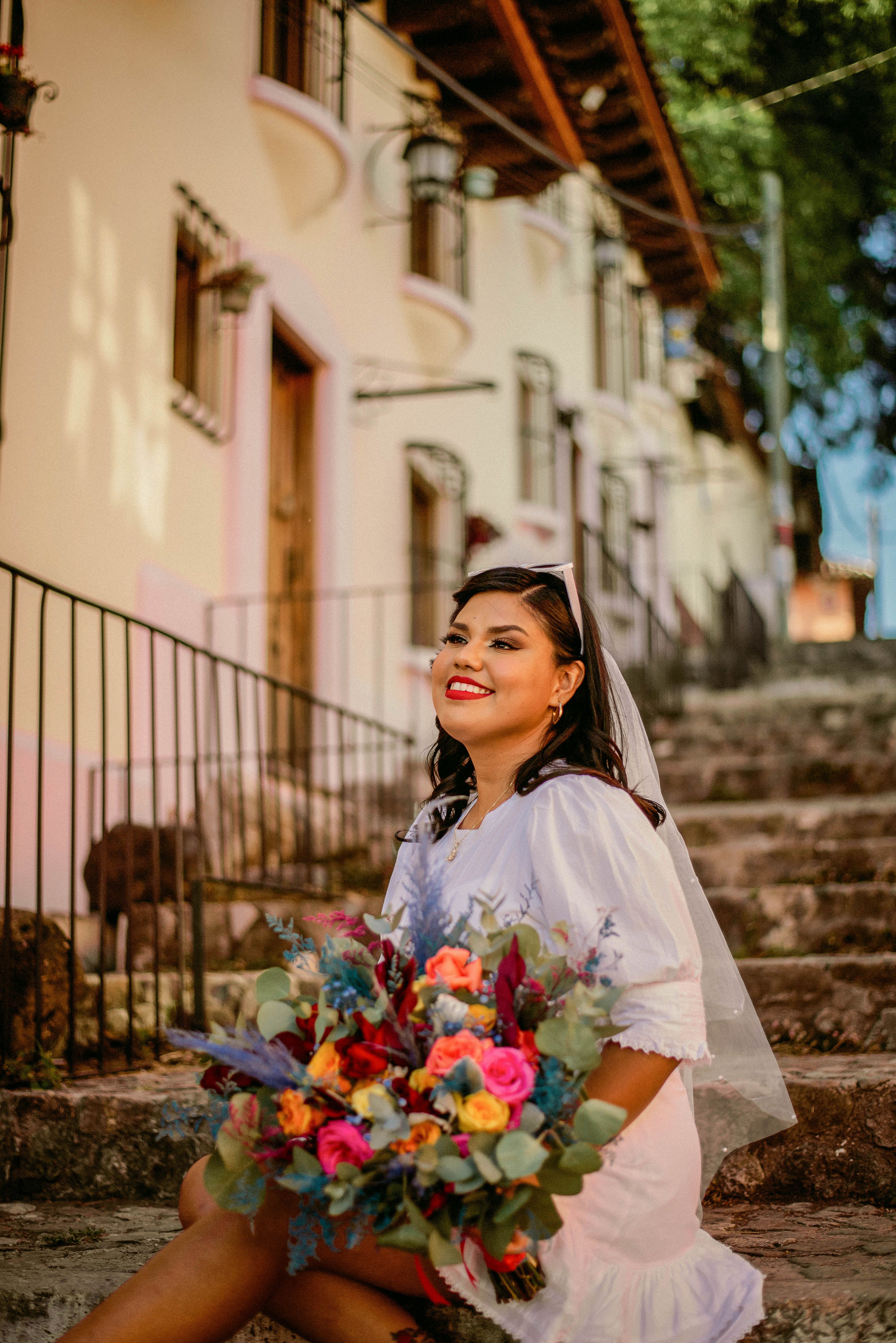 Portrait of a Bride Sitting on Outdoor Steps with a Bouquet in Hands ...