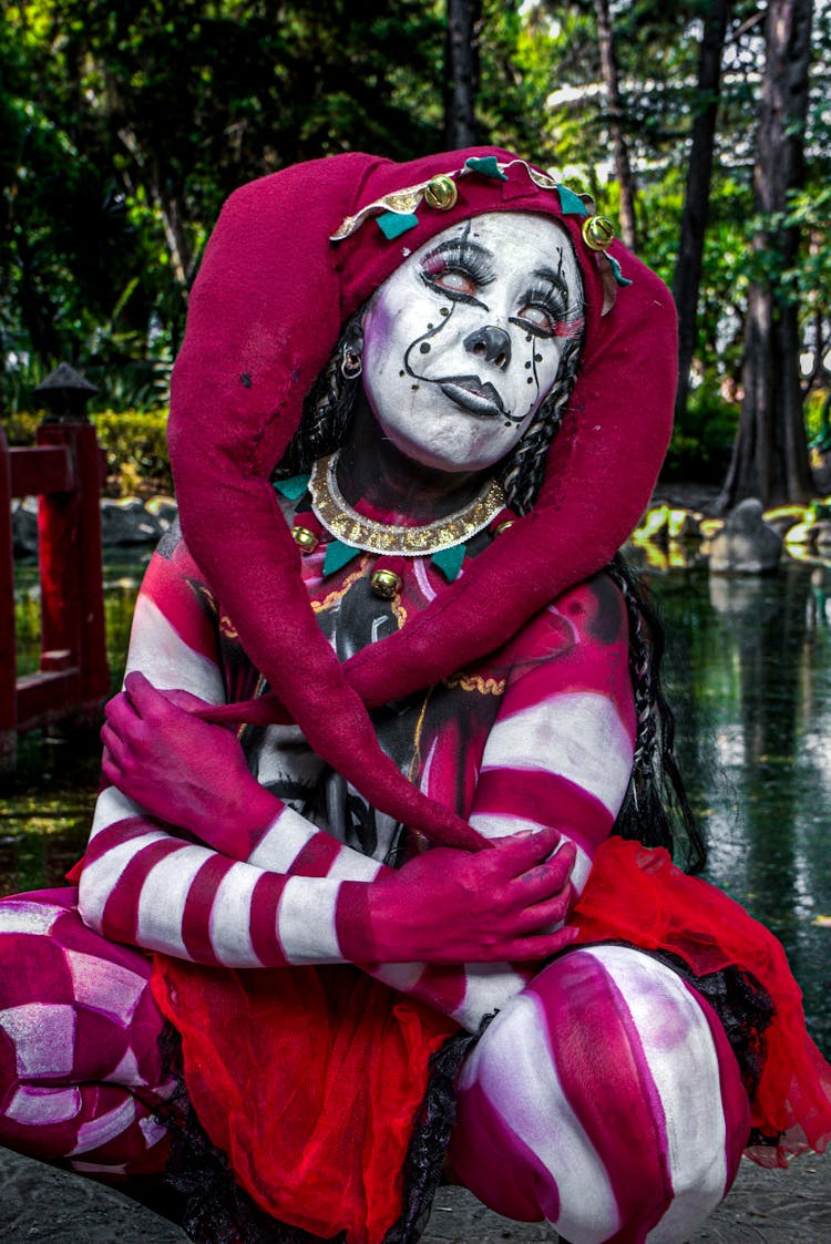 Portrait Of A Woman Wearing Body Paint And A Jester Costume