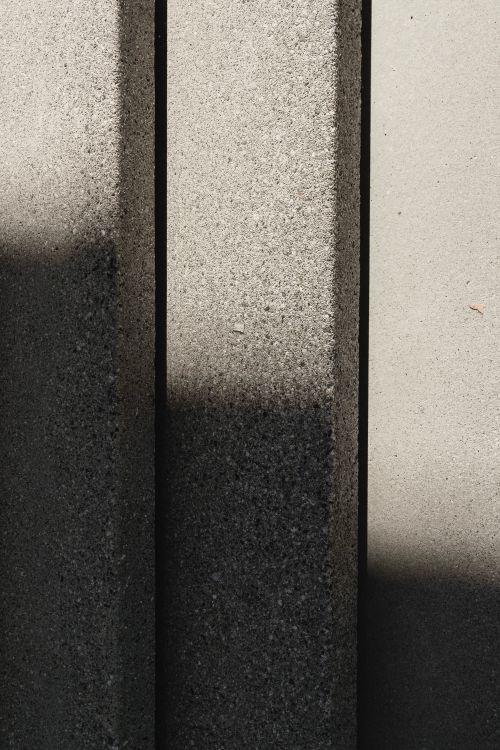 Free Vertical close-up of concrete wall surface with shadows creating abstract patterns. Stock Photo