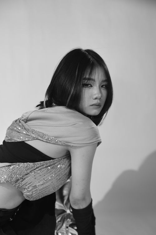 Free Stylish black and white portrait of an Asian woman in a striking pose, capturing modern fashion. Stock Photo