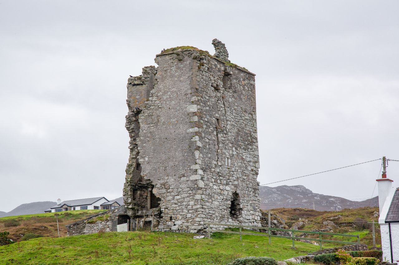 a historic stone tower ruin standing alone in a rural countryside land