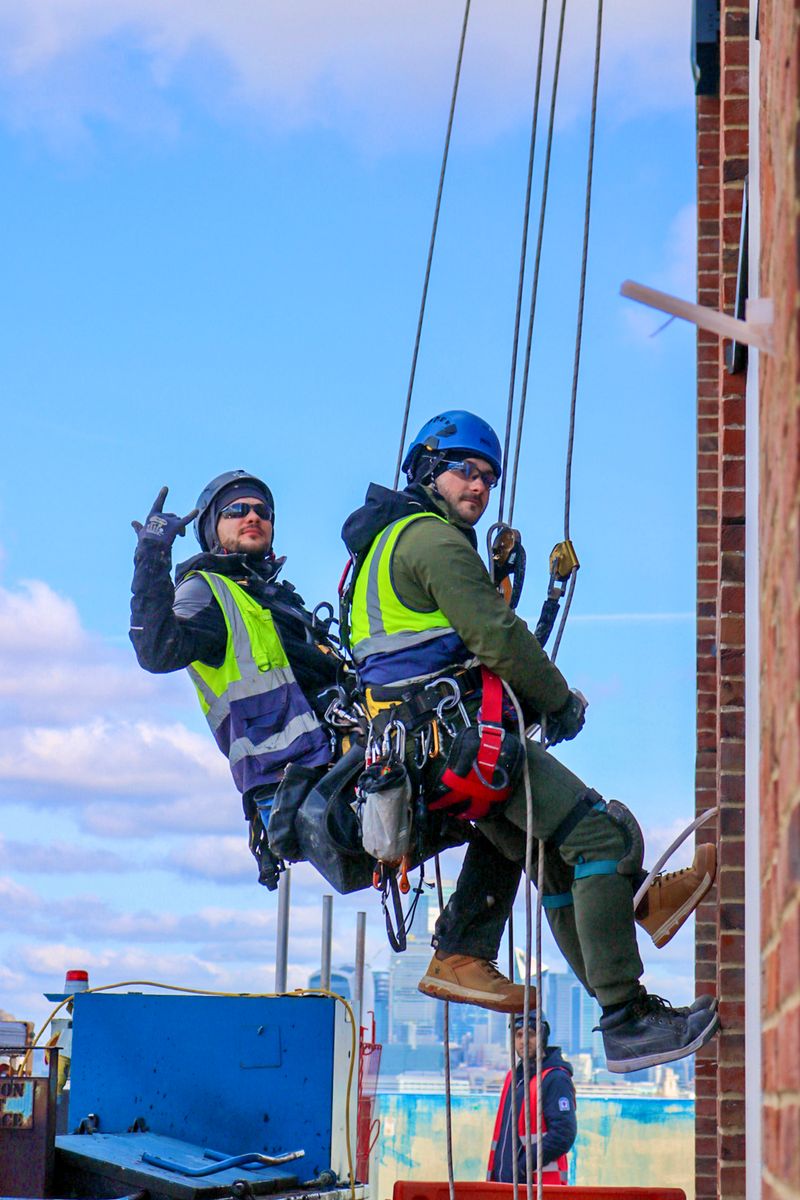 Workers using rope access and climbing equipment at height