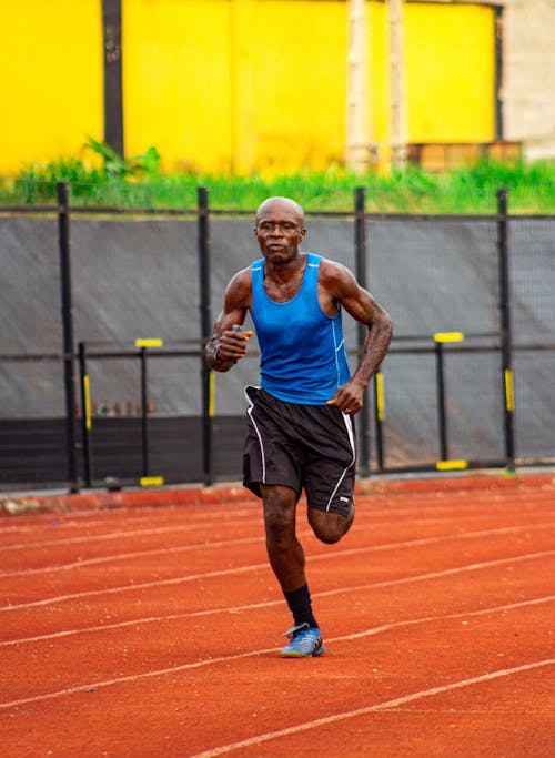 A man running on a track in a blue shirt