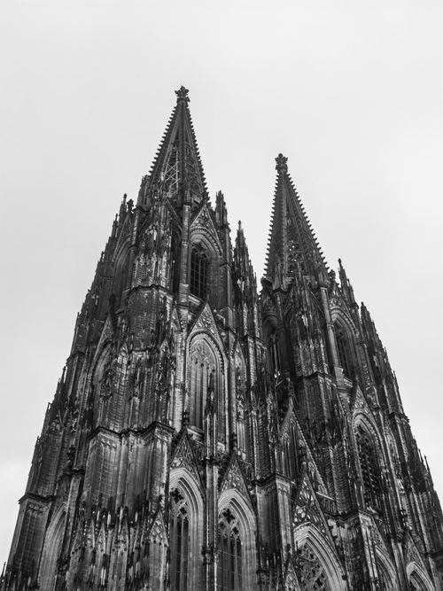 Free A dramatic black and white shot of the iconic Cologne Cathedral's gothic spires. Stock Photo