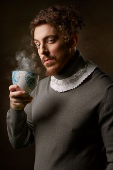 在经典的肖像设置中，卷发的男人拿着热气腾腾的咖啡杯