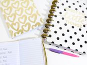 Opened Notebook Beside Pink and Purple Pen and White and Black Polka-dot Notebook