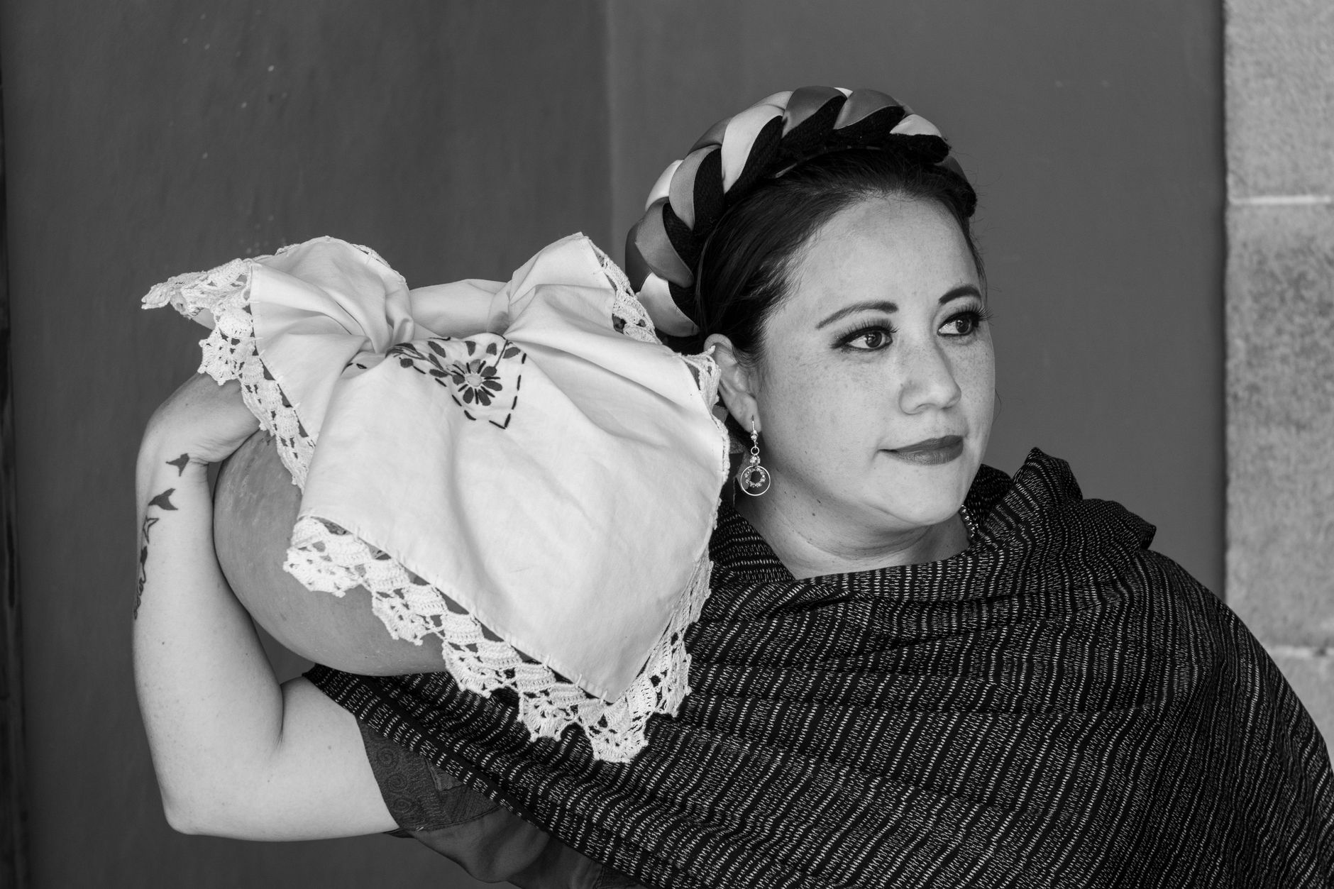 Portrait of a Mexican woman in traditional clothing holding a pot, showcasing Mexican culture.