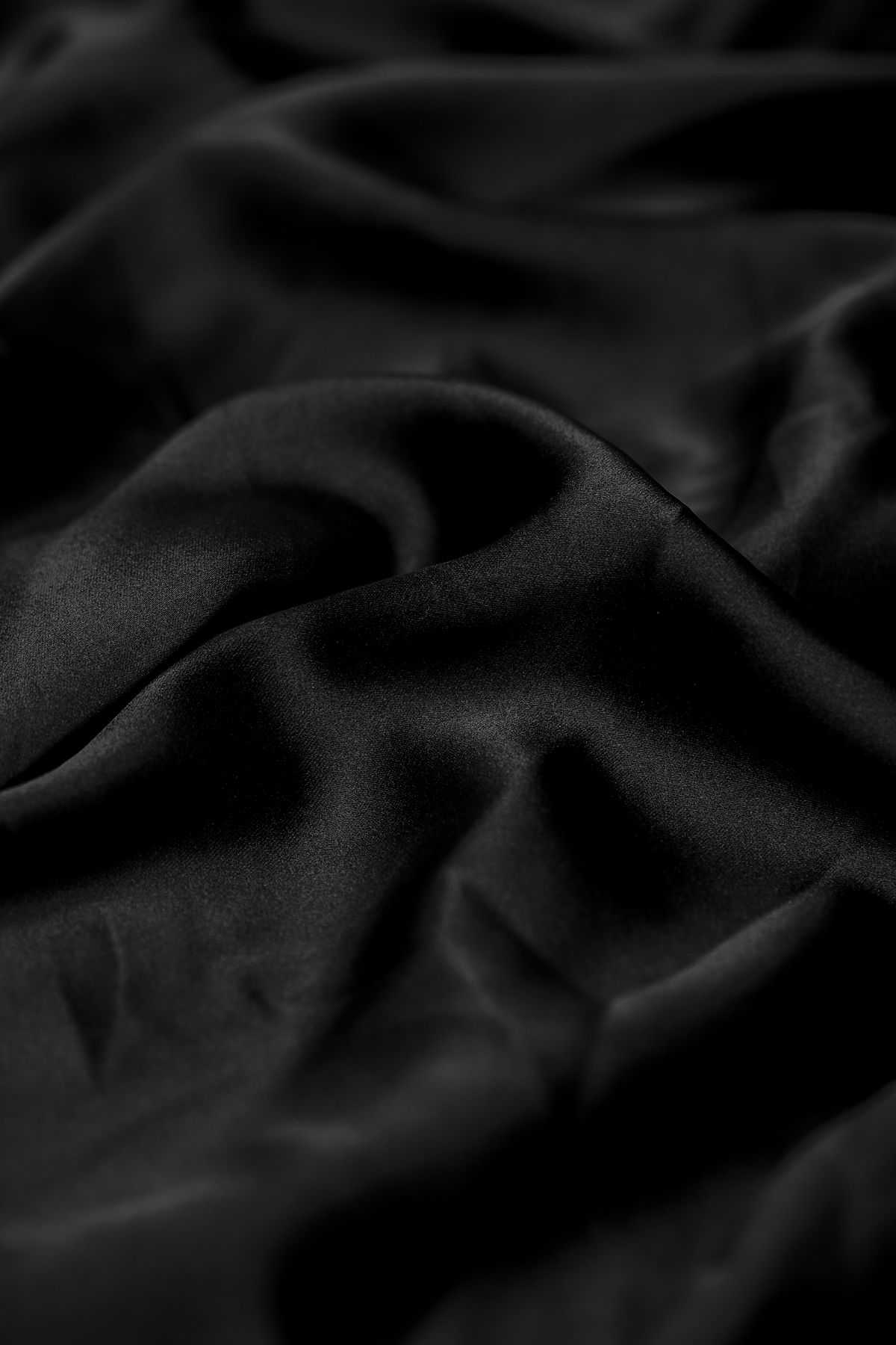 Close-up of black silk with soft folds — photo by Laura Chouette on Pexels