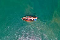 一架无人机从空中俯拍，捕捉到一艘渔船在印度尼西亚万丹附近的热带水域中航行