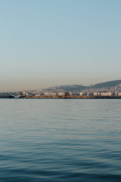 A boat is floating in the water near a city