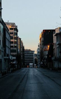 A tranquil urban street scene capturing the essence of İzmir at sunset with buildings and clear sky.