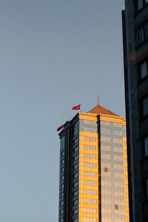 A tall building with a flag flying in the sky
