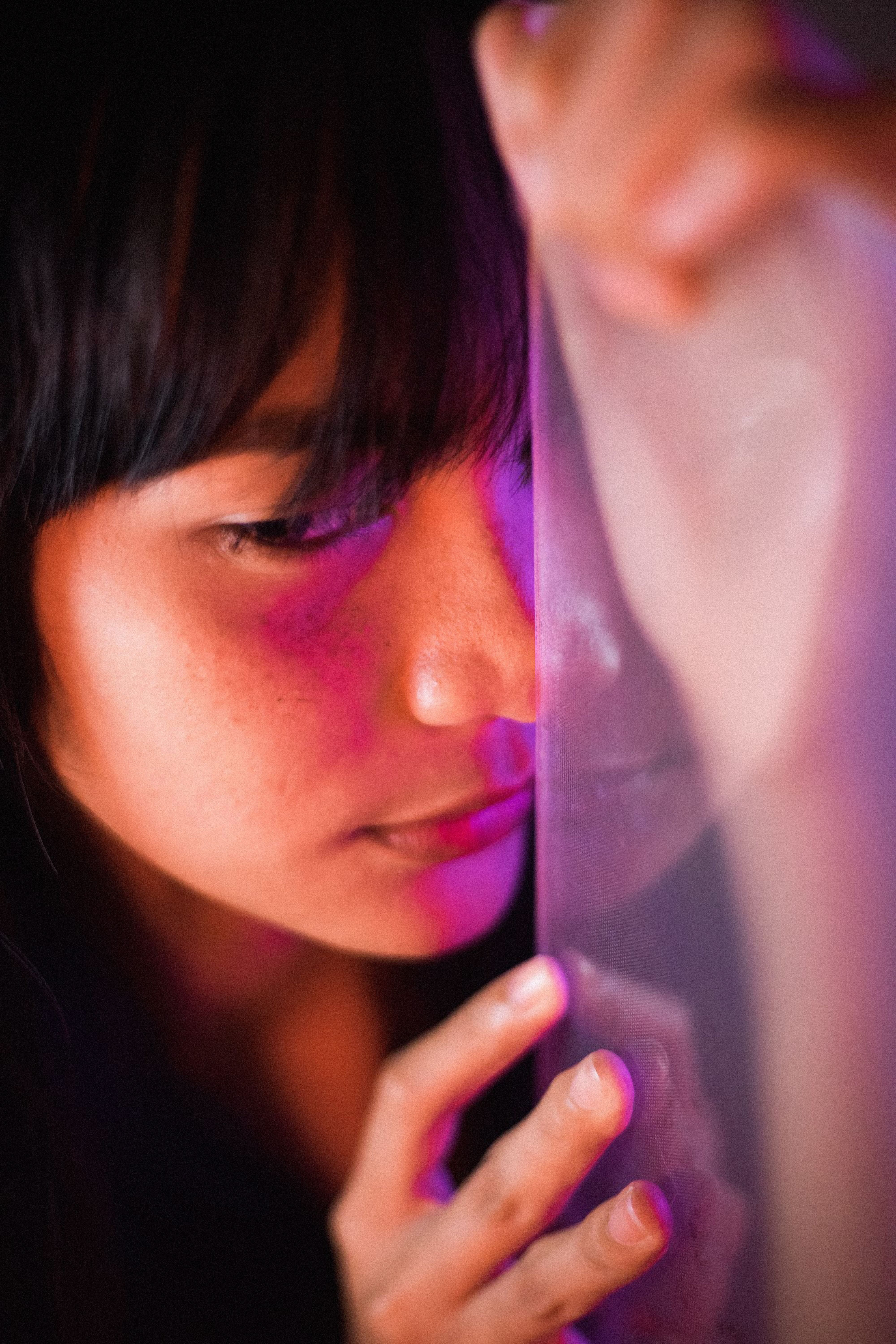 A creative portrait of a woman with reflection against frosted glass, capturing unique lighting and mood.