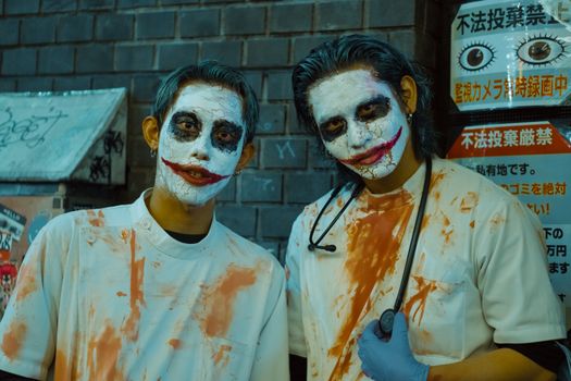 Men in Joker costumes with face paint celebrating Halloween in Shinjuku, Tokyo, Japan.