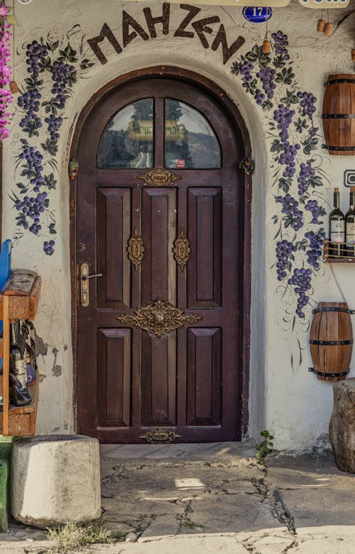 A door to a small shop with flowers and grapes