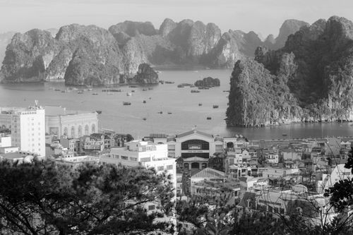 Free A breathtaking black and white cityscape of Ha Long Bay, showcasing its iconic limestone formations and urban life. Stock Photo