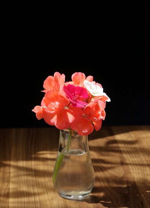 A vase with pink flowers in it on a table