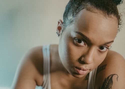 Free Close-up portrait of a woman with tattoos and nose ring, conveying a bold and artistic style. Stock Photo
