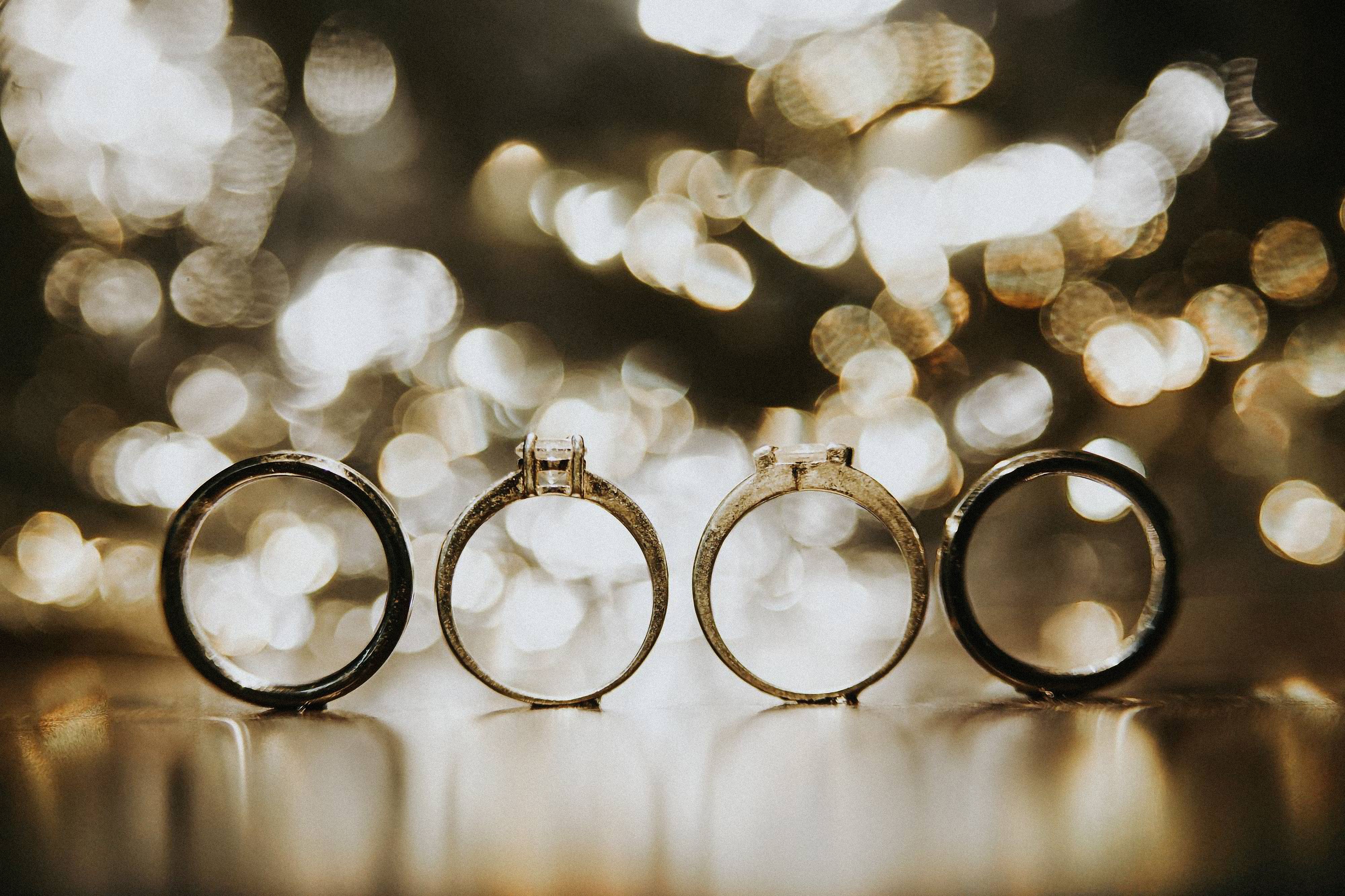 Four elegant wedding rings in bokeh lighting, perfect for symbolic and engagement themes.