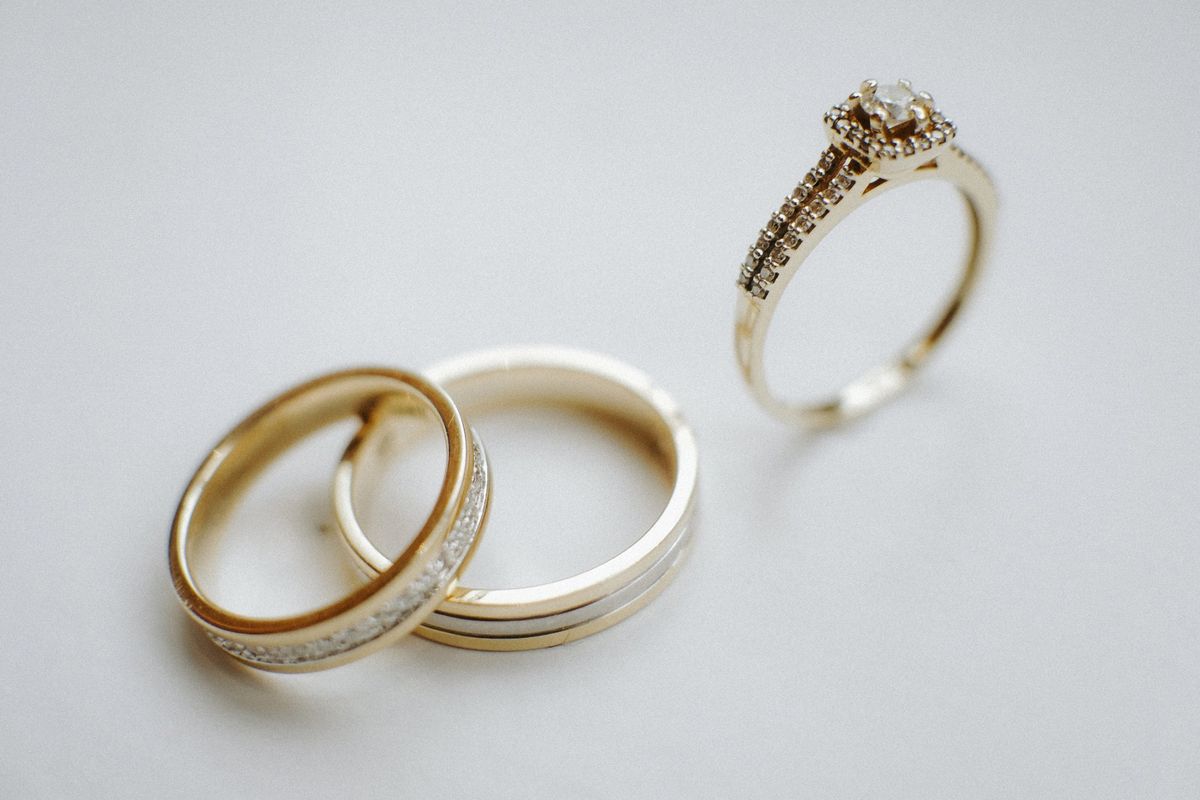 Gold wedding and engagement rings arranged together for comparison