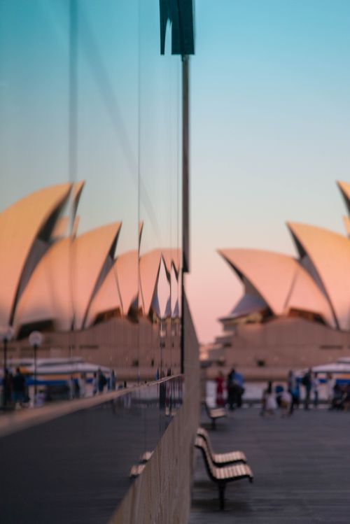 Free Sydney Opera House reflected in glass, capturing the iconic architecture at dusk in Sydney, Australia. Stock Photo