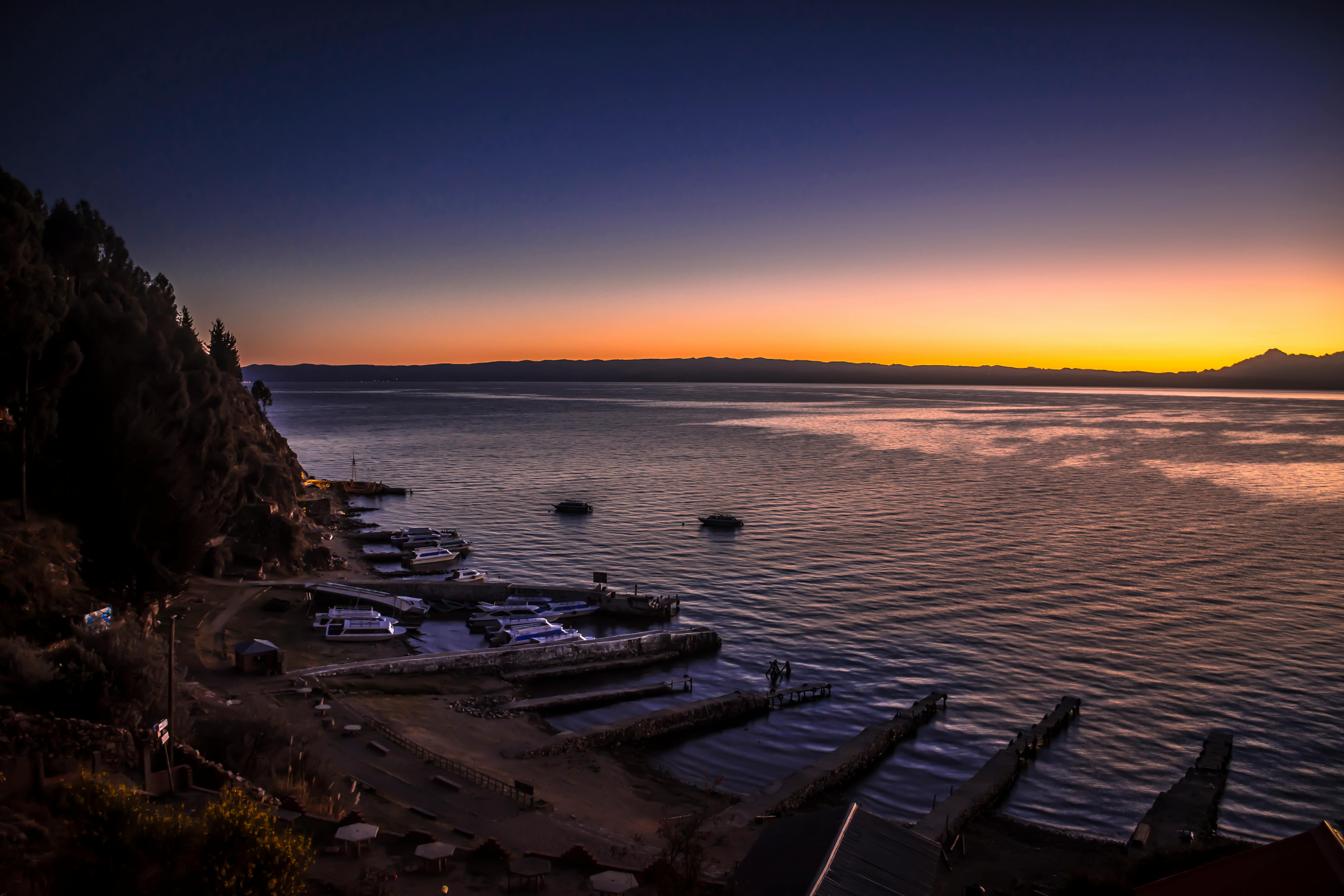 从玻利维亚的科帕卡巴纳，可以欣赏到宁静的水面与充满活力的天空映衬下的的喀喀湖壮丽日落