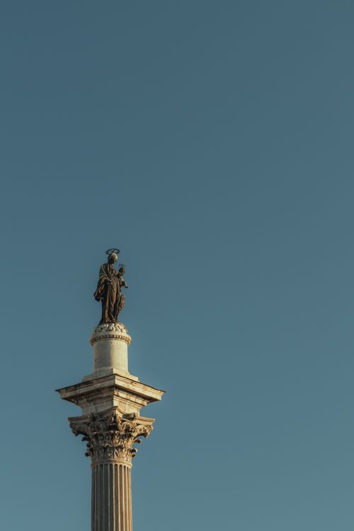 Free Monumental column with statue against a clear sky in Rome, Italy, showcasing classic architecture. Stock Photo