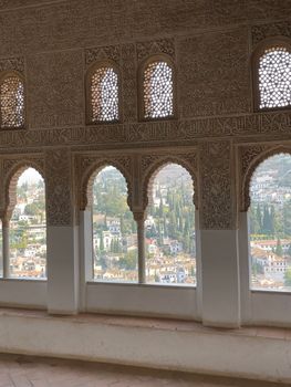 Intricate windows of Alhambra palace with a beautiful view of Granada, Spain.