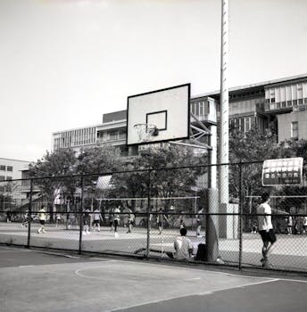Basketball game in a Taipei school court, with players and buildings in view.