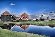 荷兰风车和传统建筑的风景倒映在池塘中