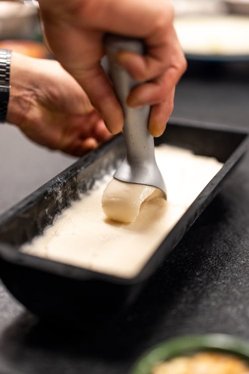 A person is using a spatula to make a cake