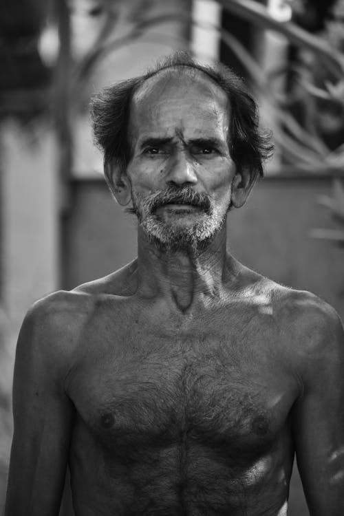 A black and white photo of a man with no shirt