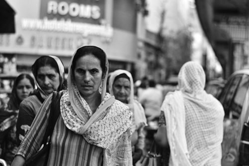 Free Black and white photo capturing women in traditional attire walking in a city street. Stock Photo