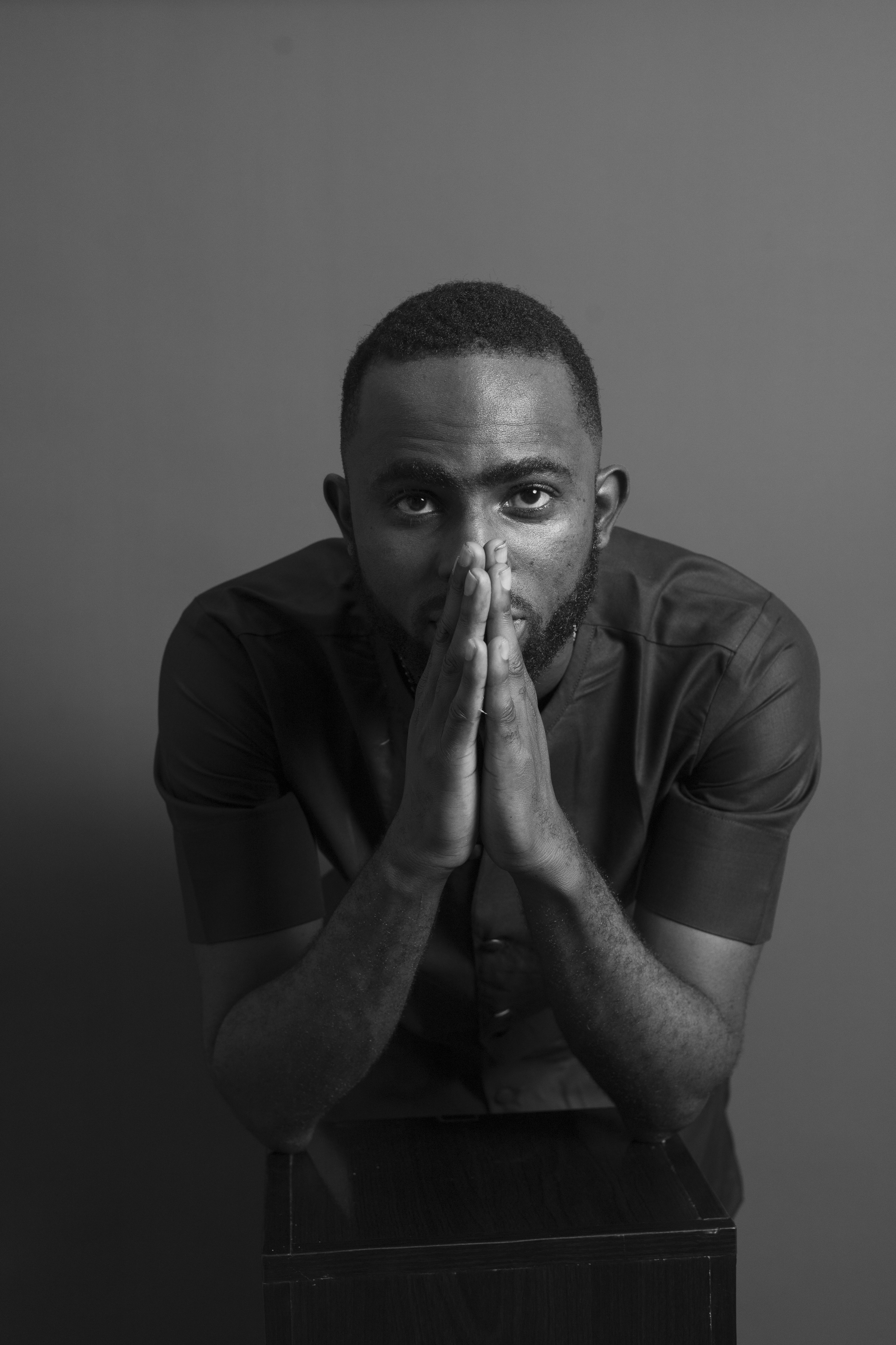 Black and White Studio Shoot of a Man with Clasped Hands · Free Stock Photo