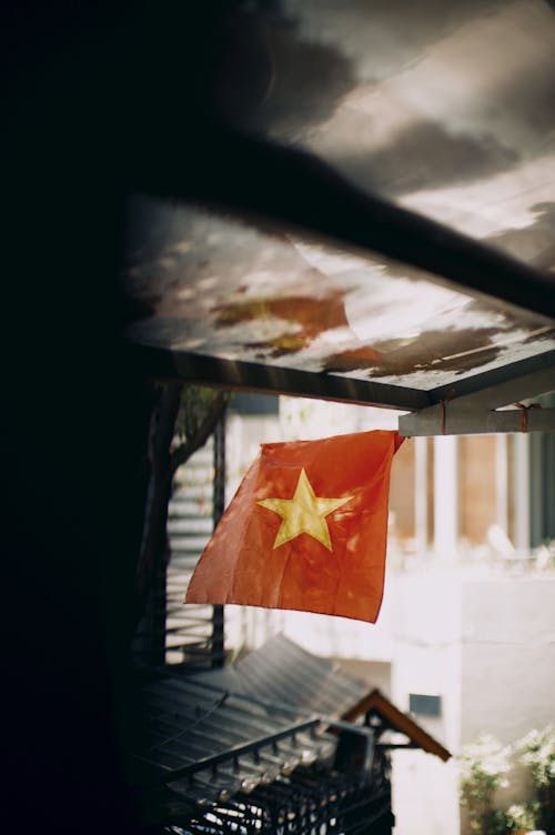 A vietnamese flag hanging from a window