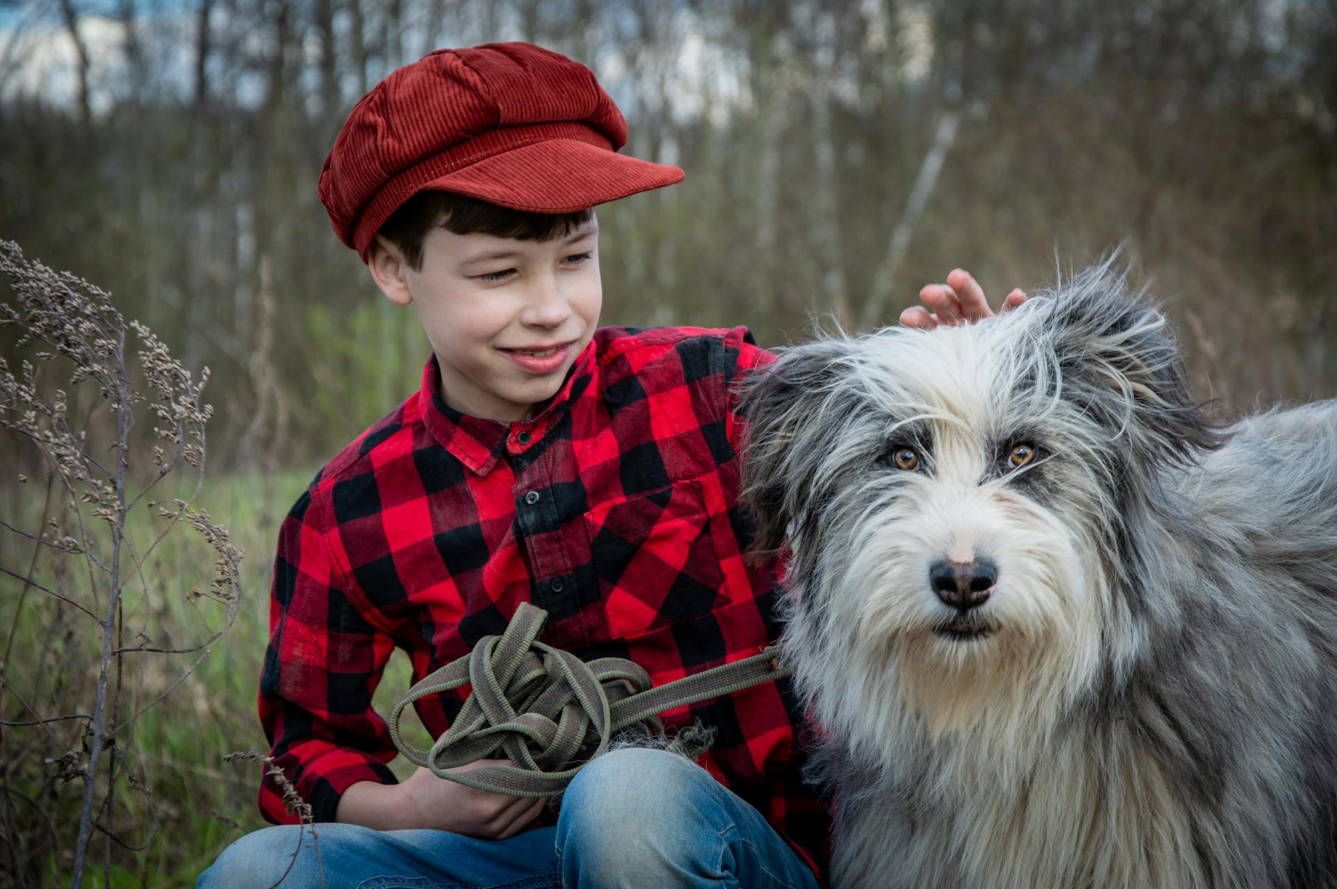 Portret van een jongen met een oude Engelse herdershond